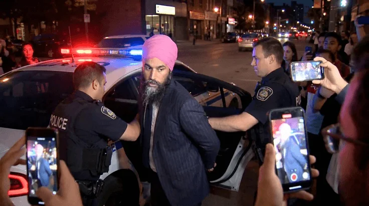 NDP former Leader Jagmeet Singh is placed into a police vehicle outside CBC studios in Ottawa
